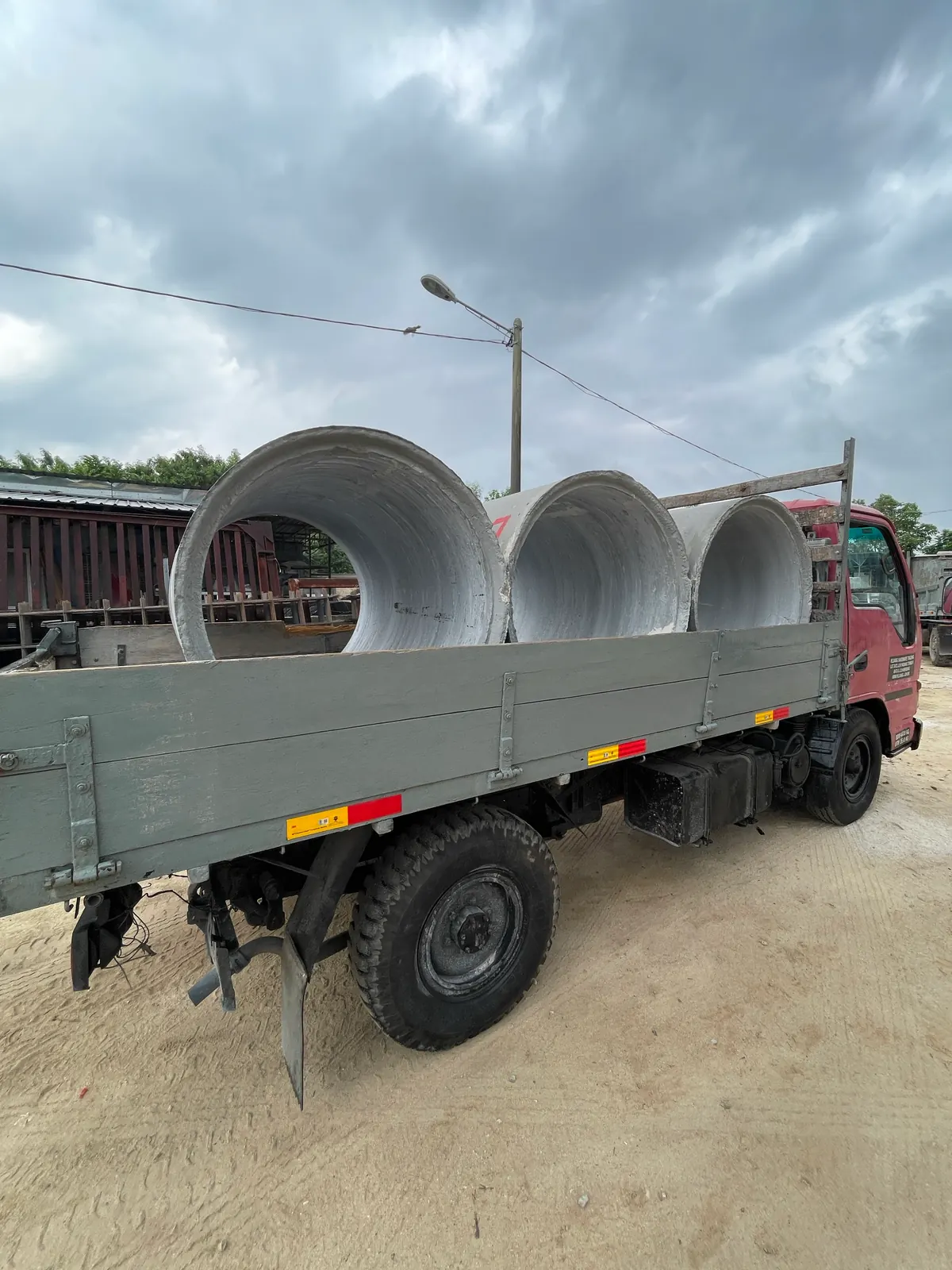 Large concrete culverts loaded on a Kluang Hardware delivery truck